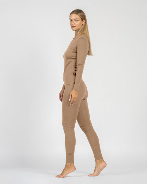 Woman wearing a beige bodysuit on a white background