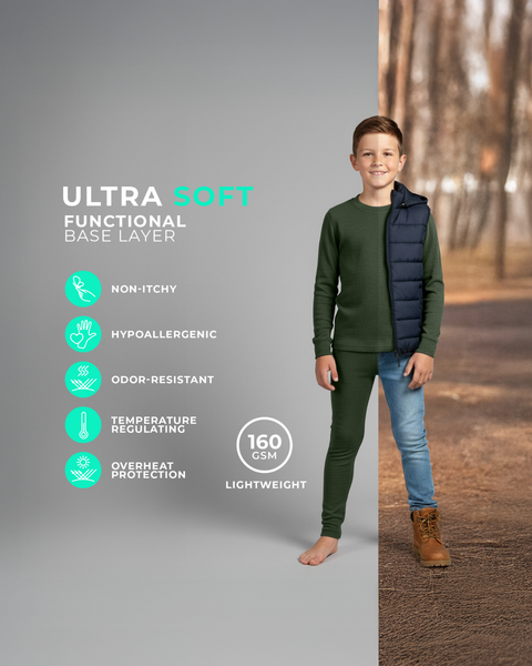 Ein Junge trägt ein dunkelgrünes langärmeliges Unterhemd und passende Leggings, steht barfuß vor einem geteilten Hintergrund, der sowohl ein Studio als auch eine herbstliche Außenszene zeigt. Symbole links heben Eigenschaften hervor wie nicht kratzend, allergikerfreundlich, geruchsabweisend, temperaturausgleichend und leichtes 160 GSM Gewebe.
