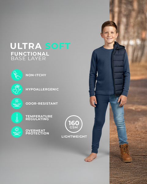 Ein Junge trägt ein langärmeliges Unterzieh-Set in Jeansblau, barfuß gezeigt vor einem geteilten Studio- und Außenhintergrund mit Symbolen für nicht juckend, allergikerfreundlich, geruchsabweisend, temperaturausgleichend und leichtes 160 GSM Gewebe.