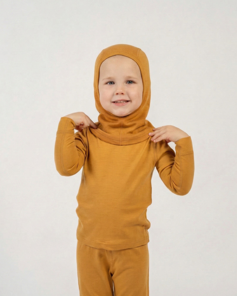 Child wearing yellow merino wool balaclava and black base layer, warm breathable winter headwear for kids.