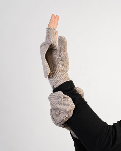 Creamy beige merino wool convertible gloves with mitten flap flipped open, shown on arm against white background.