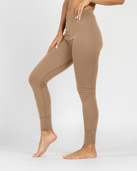 Woman wearing a beige merino wool leggings on a white background