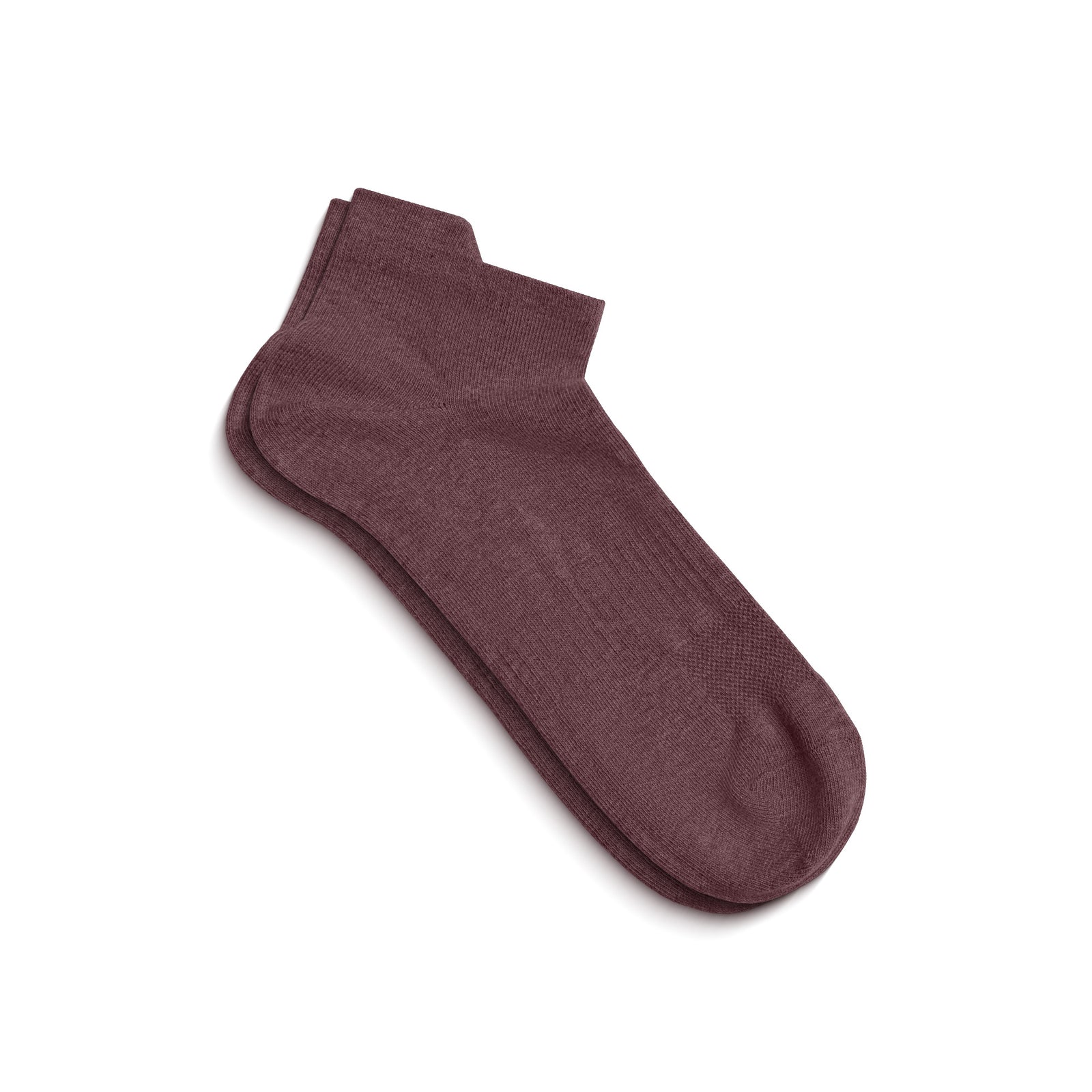 A single dark pink ankle sock shown on a foot model, angled to display the side profile and the top opening.