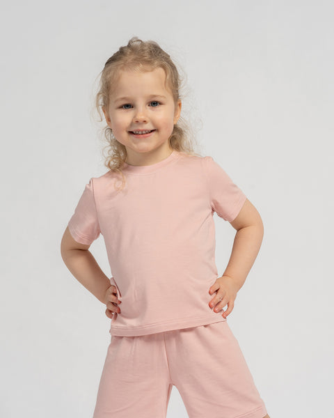 Girl wearing pink bamboo t-shirt and shorts set – soft lightweight kids loungewear outfit