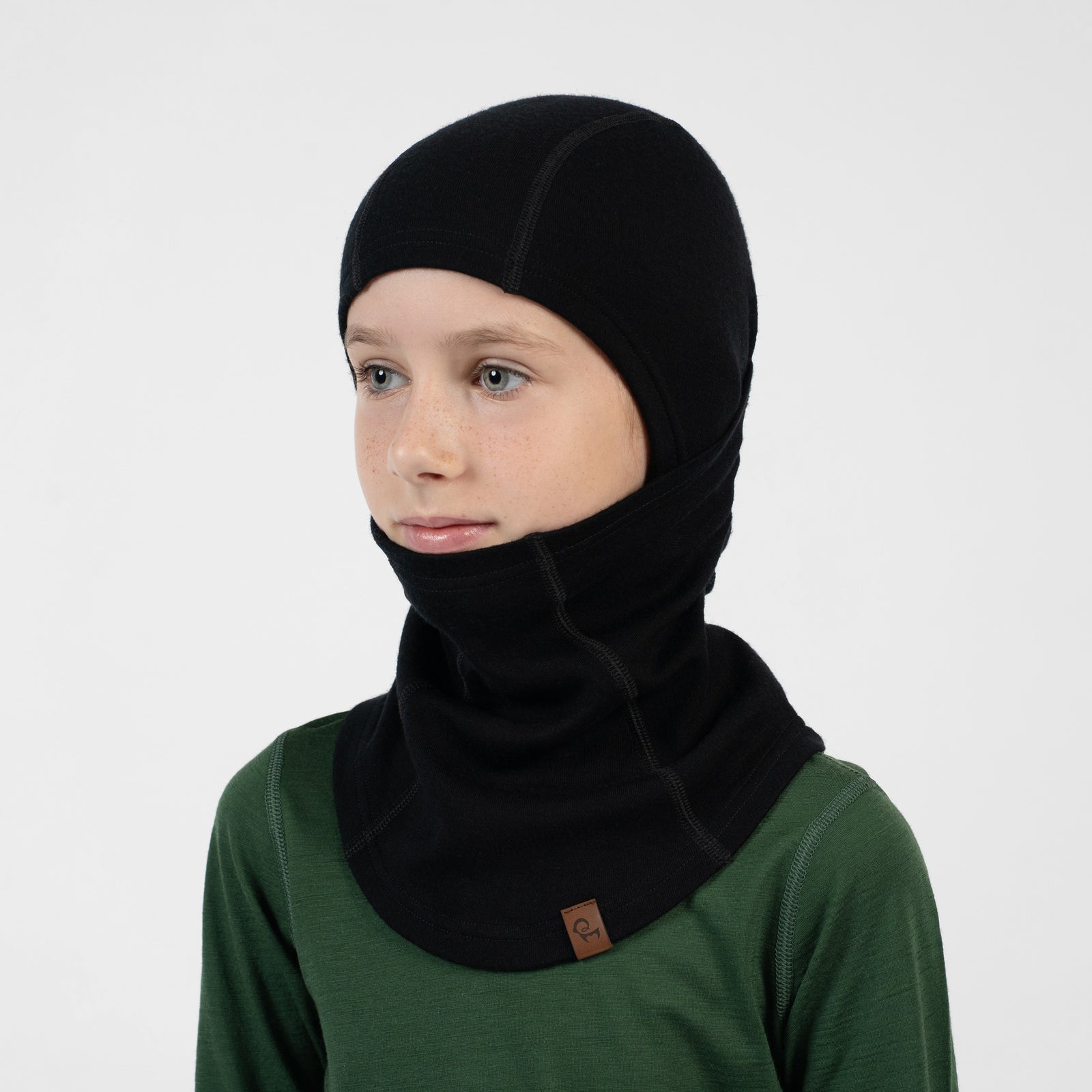 Child in a blue long-sleeve shirt wearing a black balaclava covering their head and pulled up over their nose and mouth.