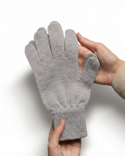 Light gray Merino wool knit glove held in hands to show fabric texture and stretchy ribbed cuff.