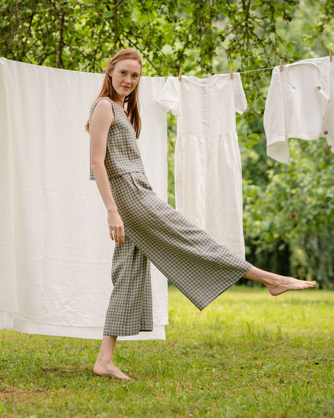 The model is standing sideways, wearing the matching green gingham two-piece, consisting of the sleeveless blouse and wide-leg pants. She has the leg closer to the camera raised, it accentuates the cropped length of the pants.