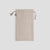 A menique stone green linen drawstring bag stands vertically against a light gray background, its natural twine drawstrings tied.