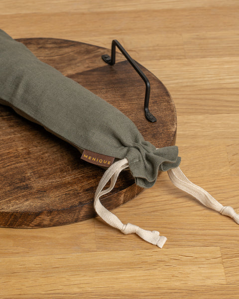Stone Green fabric bread bag with white drawstring on a wooden surface