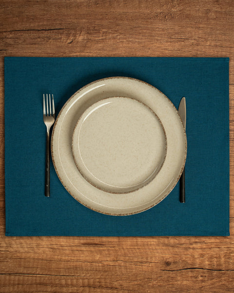 The menique linen placemat in cobalt blue color on a wooden table top.