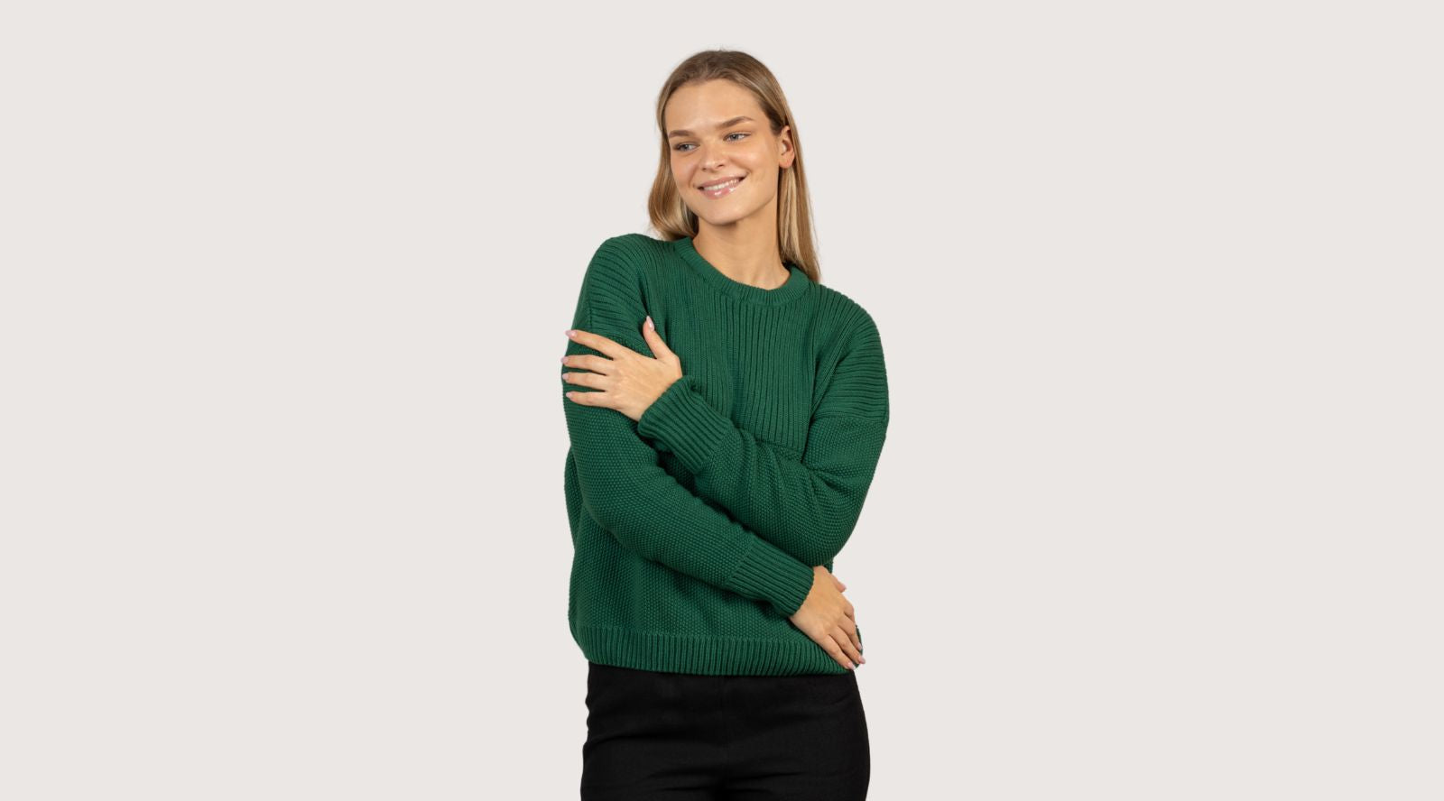 Person wearing a green sweater on a light gray background