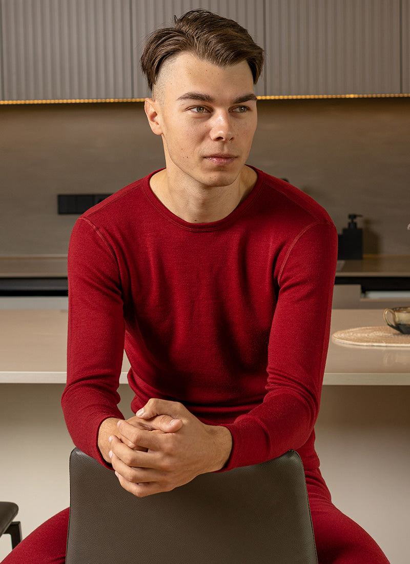 Man in red thermal long-sleeve and leggings sitting indoors