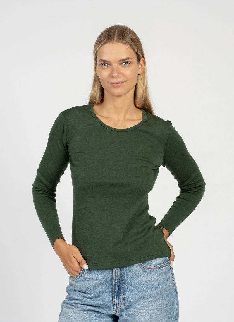 Woman wearing a green long-sleeve shirt and blue jeans on a white background