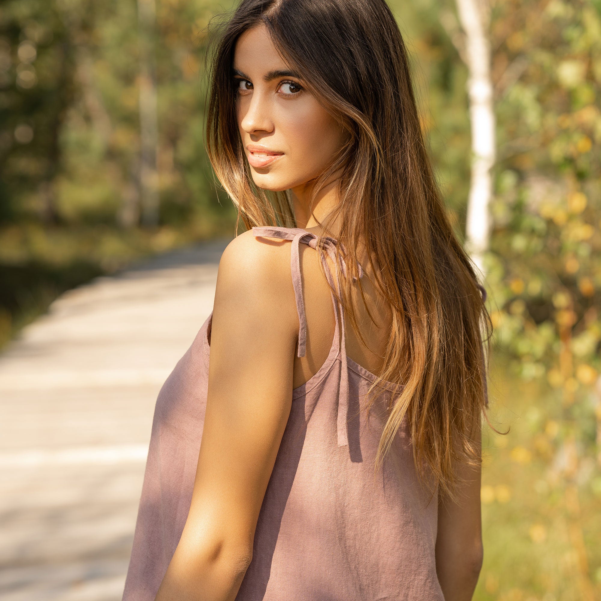 Woman wearing slip linen dress in faded rose color