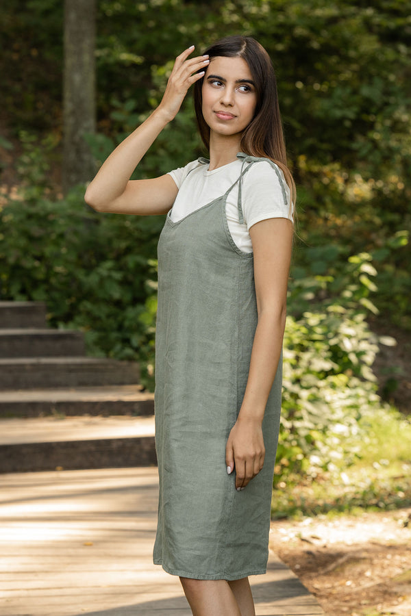 Woman standing in the forest and wearing slip dress from linen 
