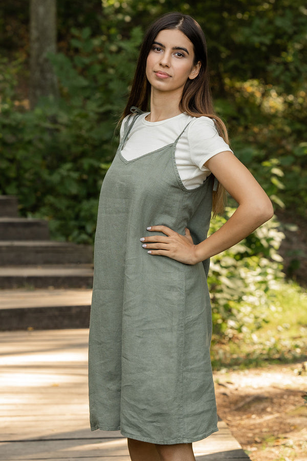 Woman standing in the forest and wearing slip dress from linen