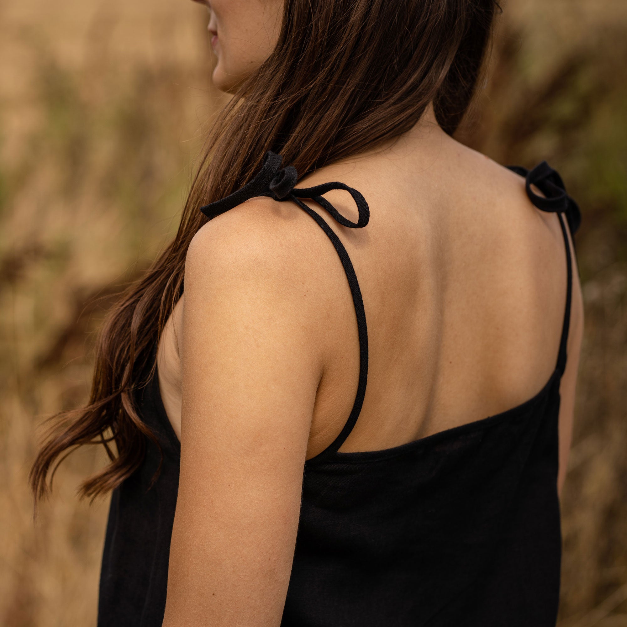 Woman standing outdoor and wearing a Liv slip dress made from linen in black color